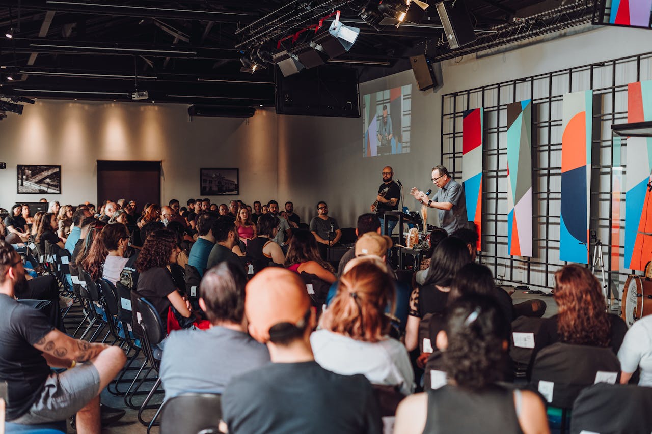 A dynamic group session in a modern auditorium with diverse participants engaged with a speaker.